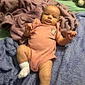 baby, infant, child, portrait, lying_down, blanket, pink_outfit, onesie, socks, smiling, wide_eyed, indoor, nursery, toy, plush_toy, bed, soft_texture, cozy, baby_furniture, photography