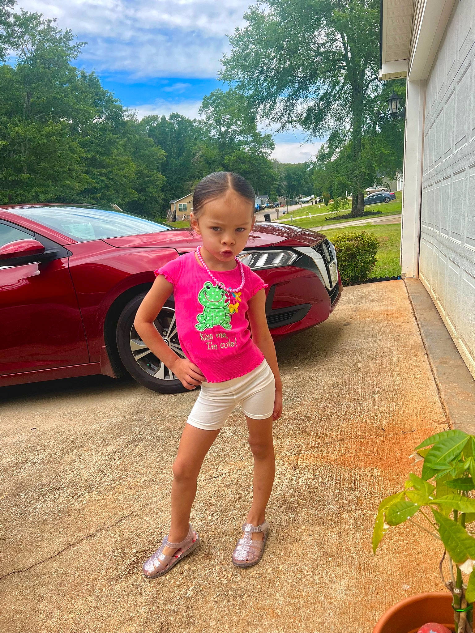 Aryanna is registered to the contest to win money with this photo: asphalt, automotive_tire, car, cloud, grass, land_vehicle, leg, leisure, morning, motor_vehicle, person, plant, shorts, sky, tire, toddler, tree, vehicle, vehicle_door, wheel
