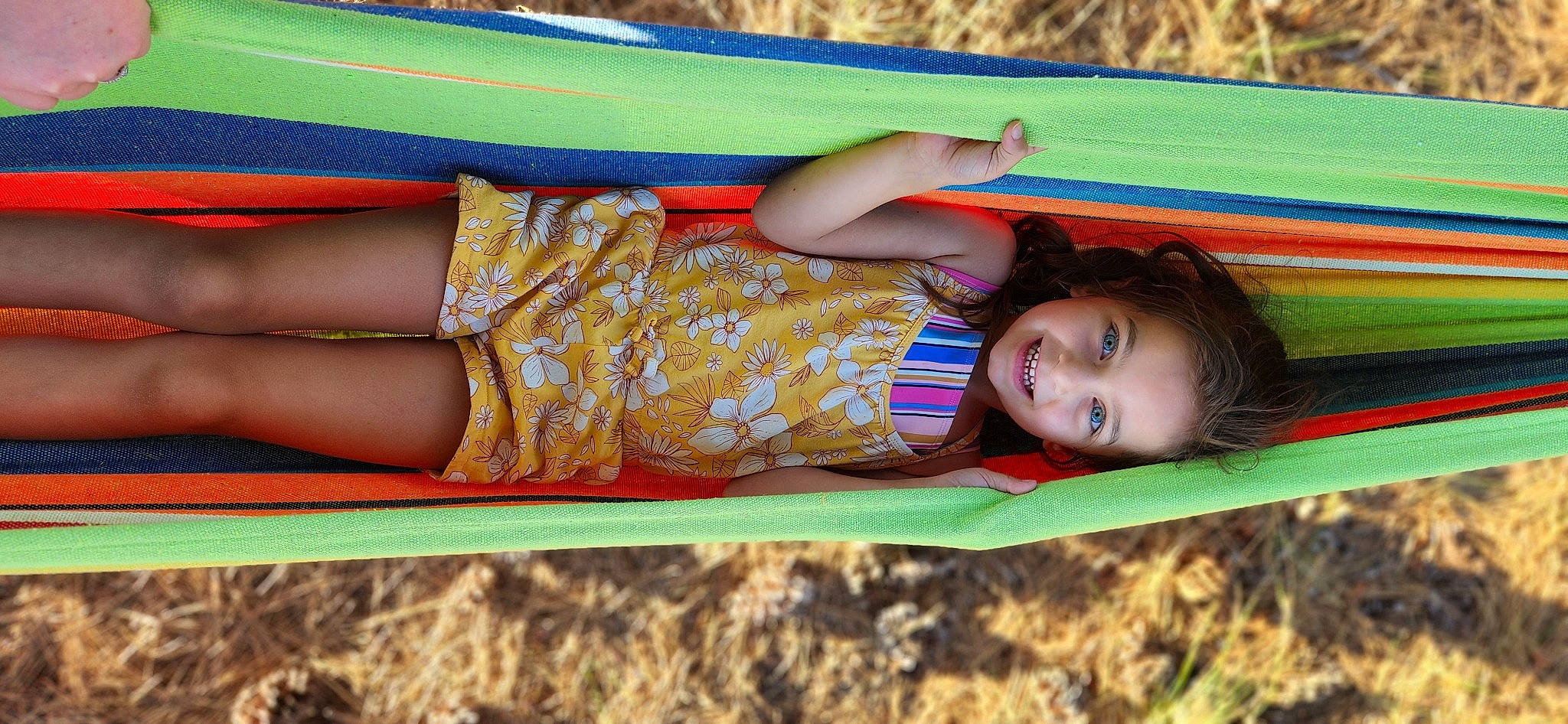 Willow is registered to the contest to win money with this photo: child, city, electric_blue, fun, grass, happy, human_leg, joy, knee, leisure, long_hair, outdoor_play_equipment, people_in_nature, person, plant, play, recreation, sitting, thigh, toddler