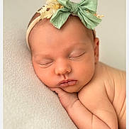 Elena participe au concours pour gagner de l'argent avec cette photo : newborn, baby, sleeping, headband, green_bow, flower, peaceful, soft, skin, portrait, infant, closeup, cute, resting, child, toddler, young, adorable, natural_light, calm