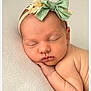 newborn, baby, sleeping, headband, green_bow, flower, peaceful, soft, skin, portrait, infant, closeup, cute, resting, child, toddler, young, adorable, natural_light, calm