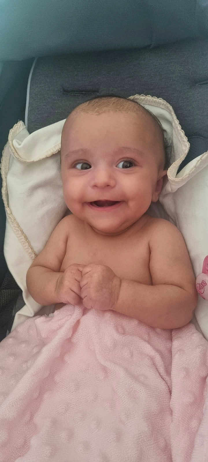 Louana a rejoint le concours — aidez-le/la à gagner de superbes lots ! baby, smiling, blanket, pink, infant, cute, child, portrait, happy, skin, hands, face, head, cushion, comfort, clothing, lying_down, indoors, hood, expression