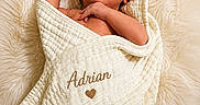 Adrian joined the competition — help win amazing prizes! baby, blanket, close_up, cozy, cream_color, curious_expression, embroidered_name, face, fluffy_rug, heart_symbol, hooded_towel, infant, lying_down, newborn, portrait, skin, small_hands, soft_texture, towel, wrapped