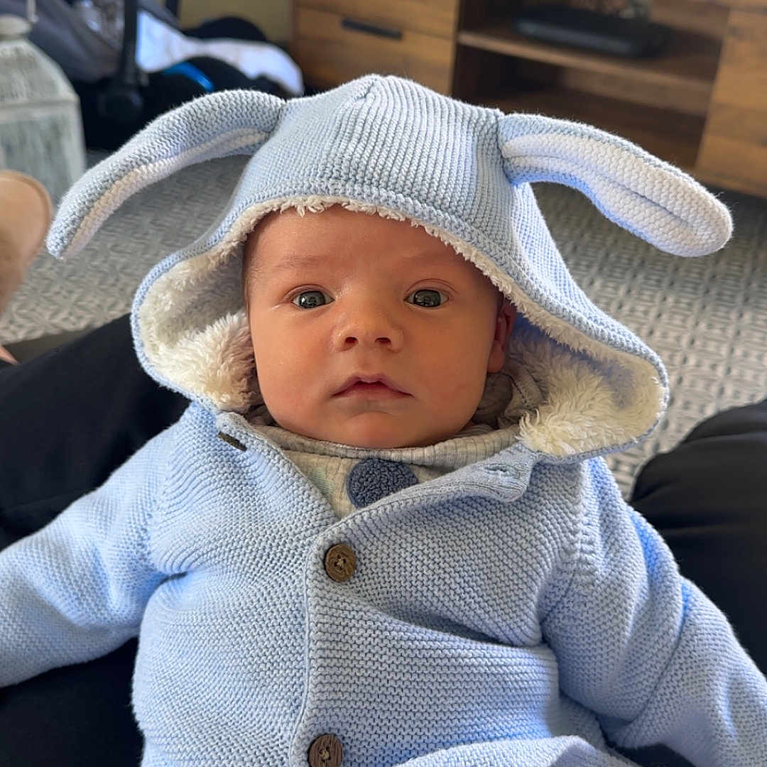 Luca joined the competition — help win amazing prizes! baby, bonnet, cap, clothing, computerhardware, couch, electronics, face, furniture, hardware, hat, head, knitwear, monitor, pants, person, photography, portrait, screen, sweater