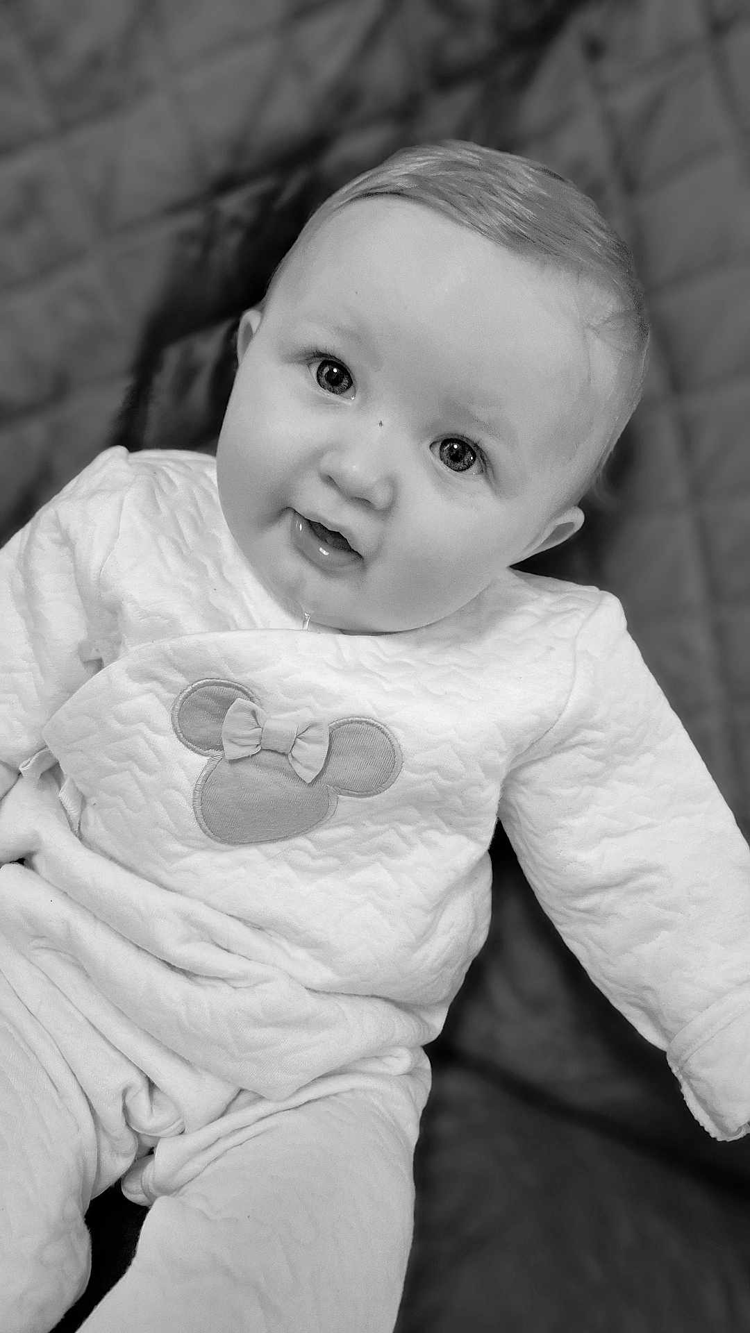 Emmy a rejoint le concours — aidez-le/la à gagner de superbes lots ! baby, infant, child, face, eyes, cheeks, drooling, onesie, mickey_mouse, bow, black_and_white, portrait, close_up, smile, gaze, soft_texture, blanket, seated, cute, hair