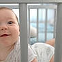 Barbara a rejoint le concours — aidez-le/la à gagner de superbes lots ! baby, crib, smile, face, eyes, infant, onesie, bars, crawling, happy, child, indoors, bed, soft_focus, cute, person, young, nursery, playful, skin