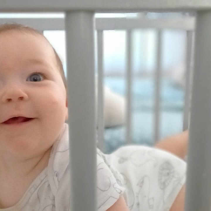 Barbara a rejoint le concours — aidez-le/la à gagner de superbes lots ! baby, bars, bed, child, crawling, crib, cute, eyes, face, happy, indoors, infant, nursery, onesie, person, playful, skin, smile, soft_focus, young