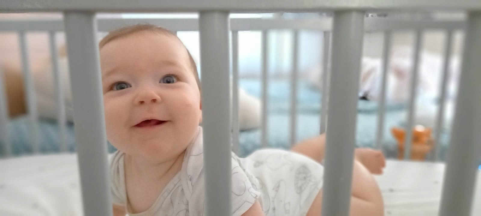 Barbara a rejoint le concours — aidez-le/la à gagner de superbes lots ! baby, crib, smile, face, eyes, infant, onesie, bars, crawling, happy, child, indoors, bed, soft_focus, cute, person, young, nursery, playful, skin