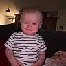 Bexley is registered to the contest to win money with this photo: baby, child, infant, smiling, sitting, couch, blanket, striped_shirt, indoors, home, portrait, face, happy, clothing, pink_blanket, furniture, candid, close_up, living_room, photograph