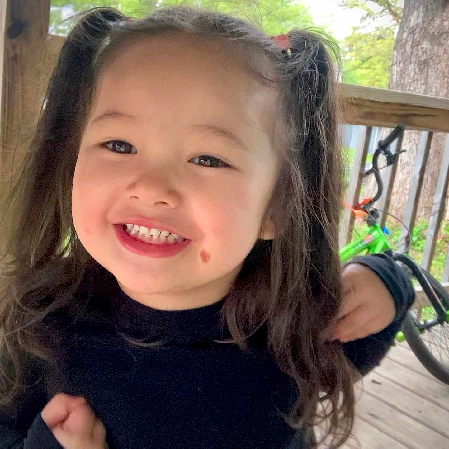 Jaimelynn joined the competition — help win amazing prizes! bicycle, casual, child, clothing, cute, daylight, face, green_bike, hair, happy, nature, outdoor, person, pigtails, porch, railing, smiling, tree, wooden_floor, young