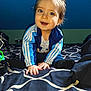 baby, bed, bedding, blanket, blue_wall, child, clothing, crawling, cute, eyes, hair, hands, happy, indoor, portrait, smiling, socks, striped_jacket, toddler, toy_ring