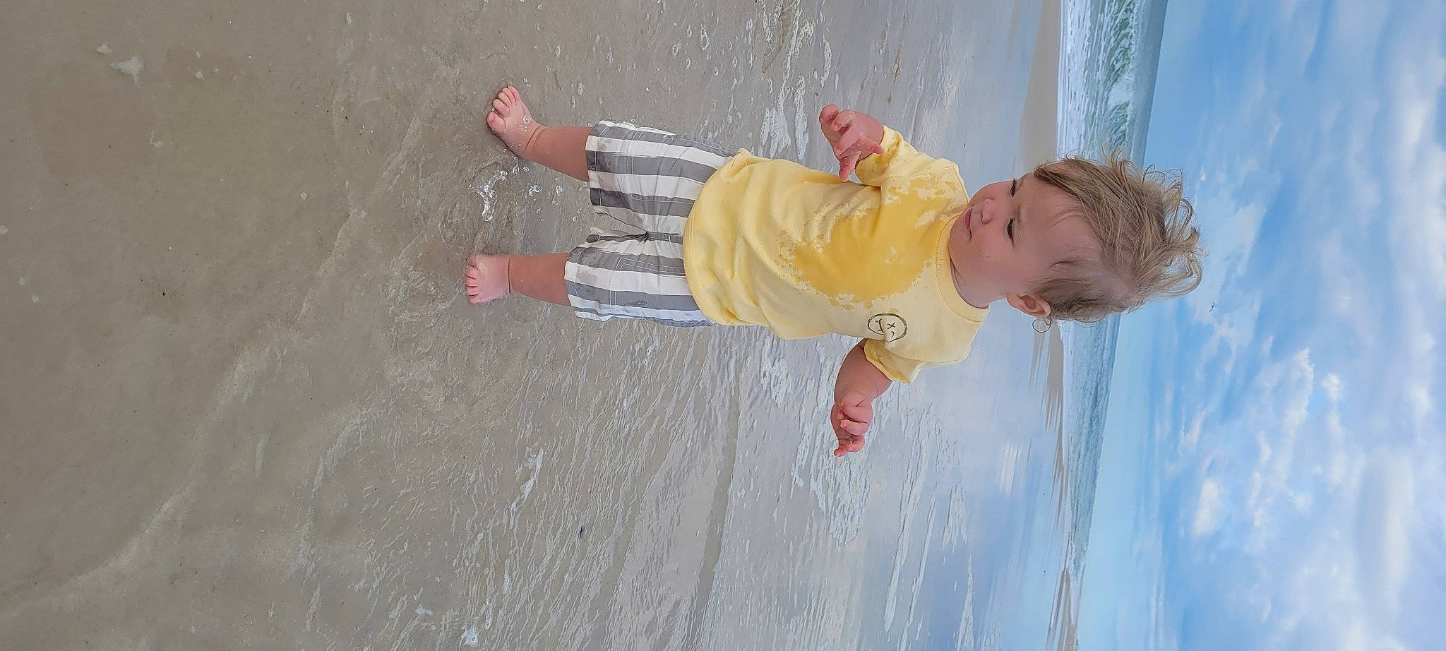 Lucas is registered to the contest to win money with this photo: baby, baby_toddler_clothing, barefoot, child, cloud, foot, fun, gesture, happy, leisure, people_in_nature, person, play, toddler, water, wood