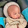 Kai is registered to the contest to win money with this photo: baby, infant, child, portrait, face, eyes, bald, bundled, blanket, clothing, sitting, car_seat, cushion, indoor, close_up, looking_away, cozy, text_overlay, emoji, family_photo