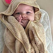 Reya is registered to the contest to win money with this photo: baby, towel, hood, mouse_ears, hand, face, blue_eyes, blanket, cute, infant, soft_texture, wrapped, smiling, child, portrait, indoors, cozy, warm, sleepy, adorable