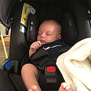 Nino participe au concours pour gagner de l'argent avec cette photo : baby, infant, sleeping, car_seat, black, blanket, foot, toes, child, indoors, seatbelt, safety, peaceful, rest, cute, small, person, soft, comfort, nap