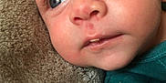 Nino a rejoint le concours — aidez-le/la à gagner de superbes lots ! baby, infant, face, blue_eyes, skin, blanket, clothing, teal_shirt, closeup, portrait, young_child, resting, soft_texture, curious, expression, head, cheeks, nose, mouth, eyelashes