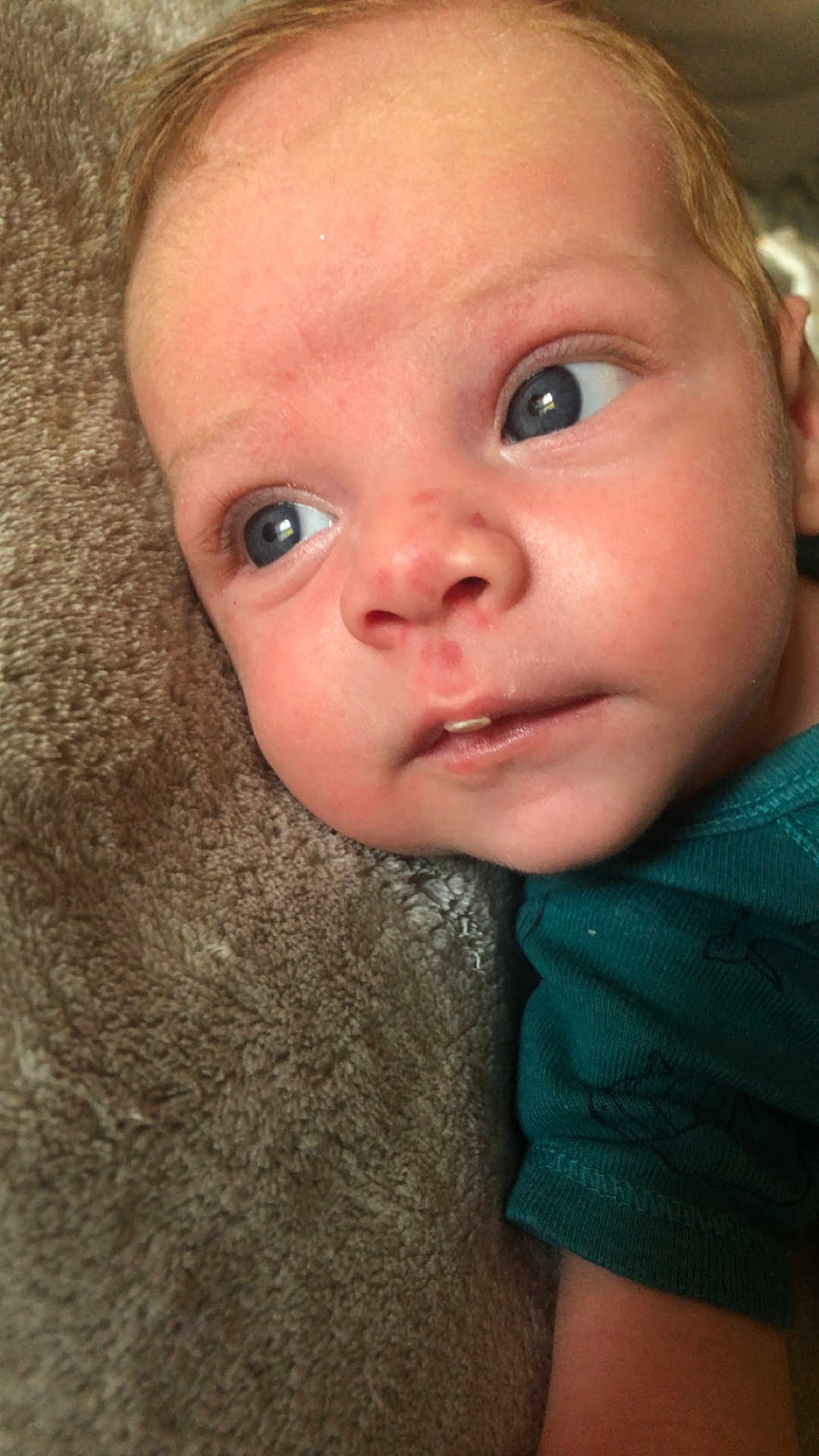 Nino a rejoint le concours — aidez-le/la à gagner de superbes lots ! baby, infant, face, blue_eyes, skin, blanket, clothing, teal_shirt, closeup, portrait, young_child, resting, soft_texture, curious, expression, head, cheeks, nose, mouth, eyelashes
