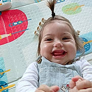 Thalia participe au concours pour gagner de l'argent avec cette photo : baby, child, smiling, play_mat, toy, colorful, happy, indoor, infant, cute, clothing, overalls, white_shirt, face, hand, foot, hair, expression, cheerful, playtime