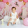 Ophelia joined the competition — help win amazing prizes! toddler, child, white_dress, balloons, pink_balloons, gold_balloons, birthday, one_year, flowers, decorations, chair, celebration, portrait, cute, smiling, indoor, party, curly_hair, baby, festive