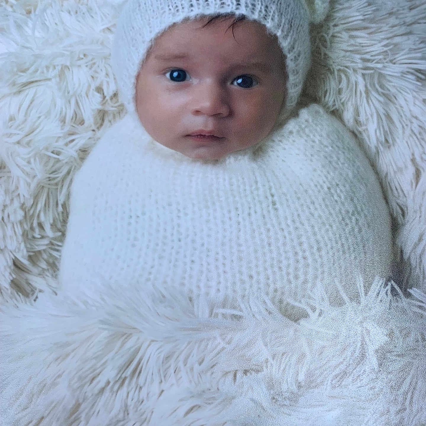 Isaiah a rejoint le concours — aidez-le/la à gagner de superbes lots ! baby, blanket, child, cozy, cute, expression, face, fur, fur_texture, headwear, indoors, infant, knit_hat, newborn, portrait, snuggled, soft_texture, warm, white, wide_eyes