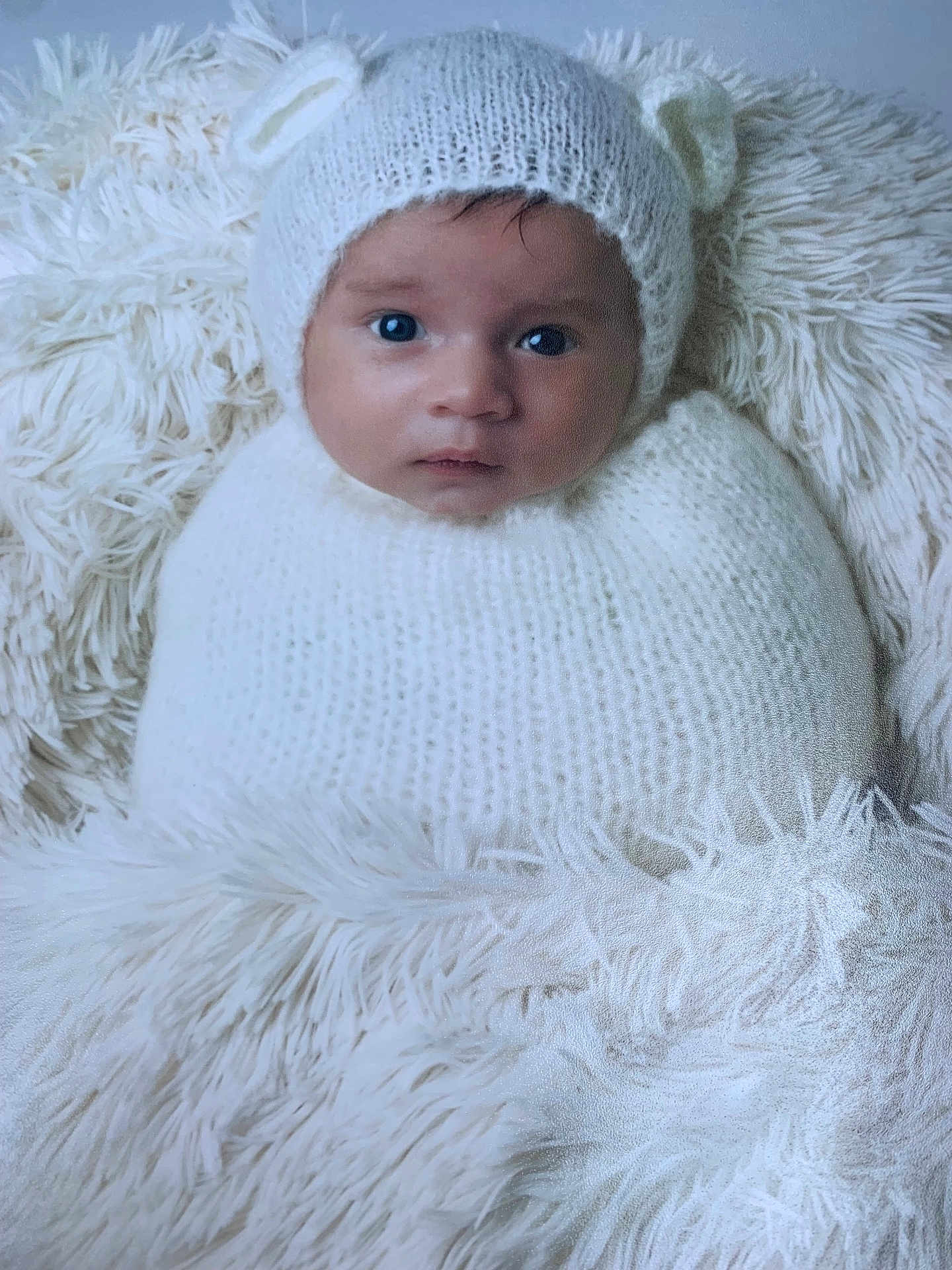 Isaiah a rejoint le concours — aidez-le/la à gagner de superbes lots ! baby, infant, knit_hat, white, cozy, blanket, soft_texture, fur, cute, portrait, child, face, wide_eyes, warm, snuggled, headwear, newborn, fur_texture, indoors, expression