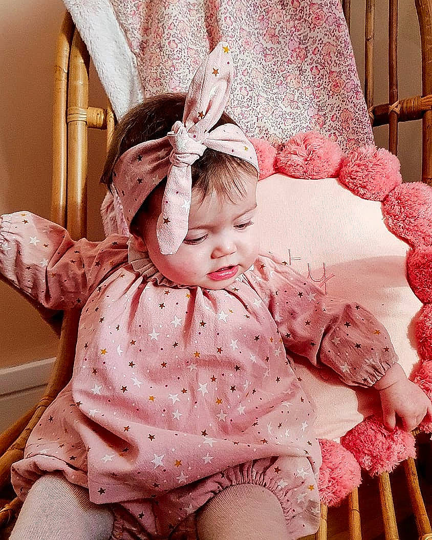 Rose participe au concours pour gagner de l'argent avec cette photo : baby, baby_sleeping, baby_toddler_clothing, child, comfort, dress, happy, head, headpiece, human_body, linens, pattern, person, pink, product, skin, sleeve, sock, textile, toddler