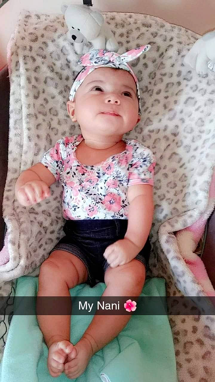 Aalani is registered to the contest to win money with this photo: baby, baby_products, baby_toddler_clothing, child, child_model, design, fashion_accessory, hair_accessory, headgear, headwear, pattern, person, pink, product, sitting, toddler