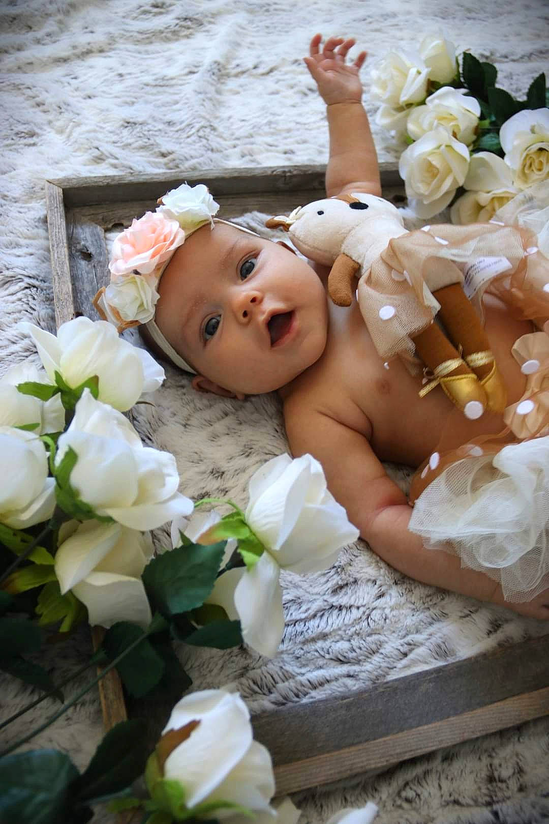 Sophie is registered to the contest to win money with this photo: artificial_flower, baby, botany, bouquet, bridal_accessory, cut_flowers, flash_photography, flower, flower_arranging, garden_roses, hand, happy, headpiece, headwear, person, petal, pink, plant, rose, rose_family