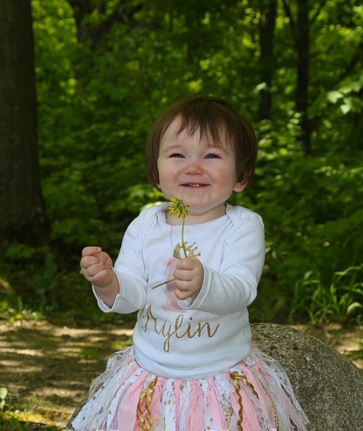 Aylin joined the competition — help win amazing prizes! baby, baby_toddler_clothing, child, facial_expression, fun, grass, happy, joy, leaf, leisure, pattern, people_in_nature, person, pink, plant, recreation, sitting, sleeve, smile, summer