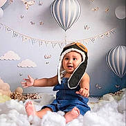 Iván Gabriel joined the competition — help win amazing prizes! baby, child, denim_overalls, aviator_hat, smiling, sitting, clouds, hot_air_balloon, indoor, decorative_bunting, butterflies, soft_toys, pastel_colors, cute, portrait, happy, toddler, playful, nursery, cozy