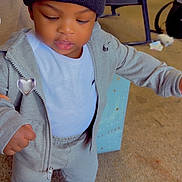 Consta joined the competition — help win amazing prizes! child, toddler, portrait, standing, indoors, beanie, heart, tracksuit, hoodie, sneakers, gray_clothing, fashion, streetwear, looking_down, serious_expression, carpet, chair, toys, living_room, full_body