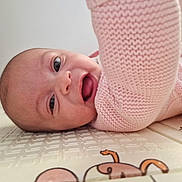 Sophia participe au concours pour gagner de l'argent avec cette photo : baby, infant, smiling, pink_sweater, knitted, lying_down, play_mat, happy, face, child, cute, indoor, closeup, person, skin, eyes, mouth, expression, baby_girl, cozy