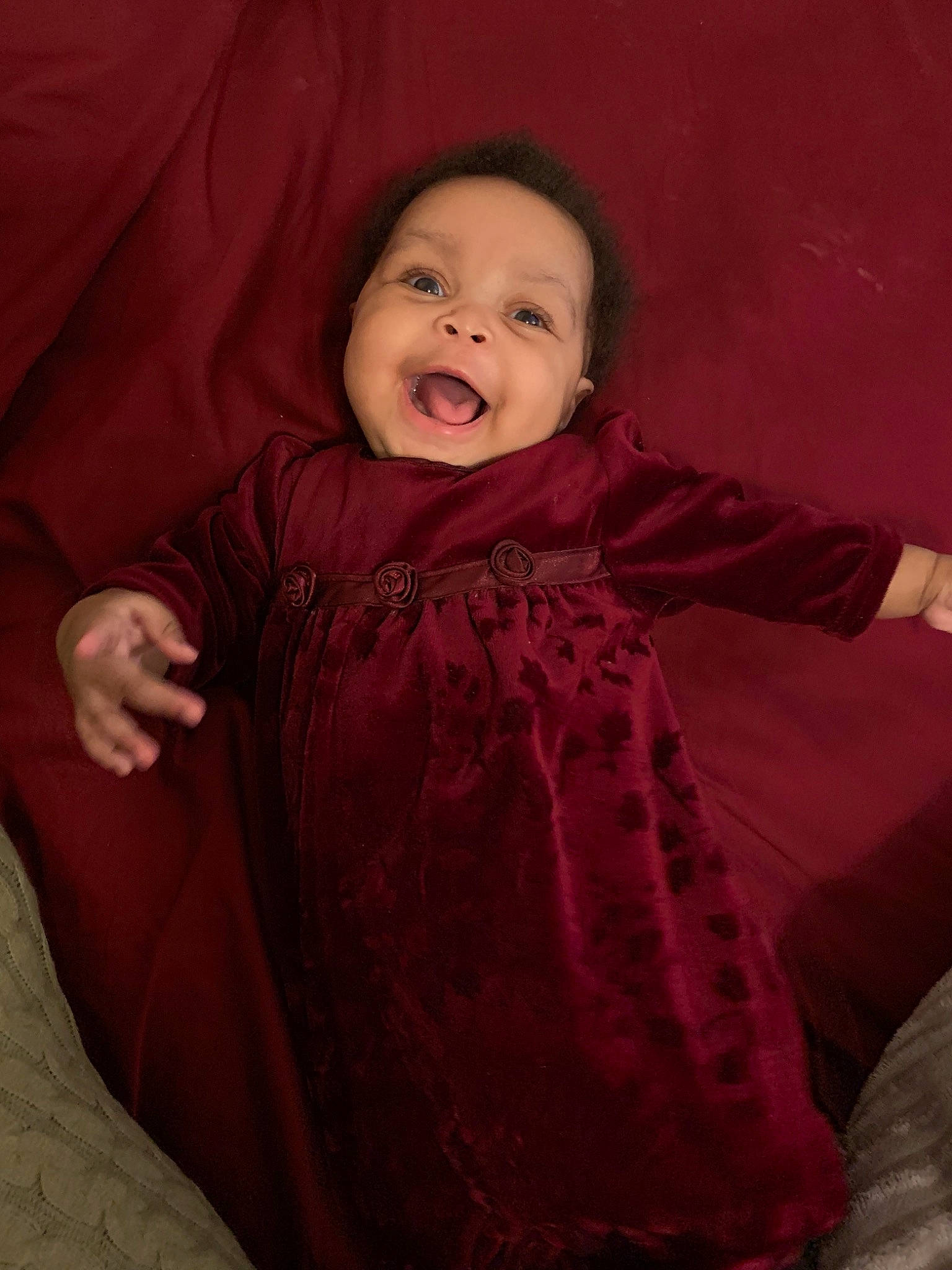 Collette is registered to the contest to win money with this photo: baby, cheek, child, eye, face, facial_expression, fun, happy, head, laugh, nose, person, portrait, portrait_photography, red, sitting, skin, smile, toddler