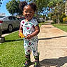 Aaliyah is registered to the contest to win money with this photo: child, toddler, smiling, tongue_out, pigtails, leaf, floral_clothing, rain_boots, sidewalk, grass, trees, sunny, outdoor, daylight, car, person, happy, cute, nature, playful