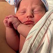 Lila is registered to the contest to win money with this photo: newborn, baby, sleeping, hat, striped_hat, hospital_blanket, wrapped, infant, cute, peaceful, skin, hand, face, closed_eyes, soft_light, portrait, indoors, human, child, newborn_baby