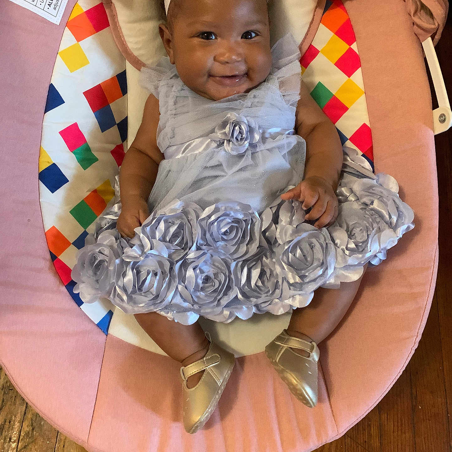 Rala joined the competition — help win amazing prizes! baby, infant, dress, flower_headband, smile, baby_seat, plush_toy, sun_toy, cloud_toy, colorful, wooden_floor, silver_shoes, happy, cute, indoors, child, person, sitting, headband, toddler