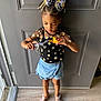 Nene is registered to the contest to win money with this photo: child, girl, toy, dinosaur, bow, hair, clothing, shorts, shoes, floor, door, indoor, standing, playing, pattern, denim, plastic, casual, cute, focused