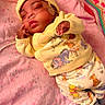 baby, sleeping, yellow_clothing, blanket, crochet_blanket, nasal_tube, infant, pajamas, pink, face, hand, cozy, cute, indoor, resting, newborn, soft_light, lying_down, child, toddler