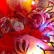 La'Ilah joined the competition — help win amazing prizes! baby, sleeping, christmas, holiday, festive, red_clothing, headband, lights, pine_cone, ornament, decoration, cozy, infant, cute, celebration, toddler, portrait, indoors, soft, warm