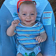 Ryder joined the competition — help win amazing prizes! baby, child, infant, smiling, happy, portrait, face, blue, stroller, seated, striped_shirt, short_sleeves, outdoor, sunlight, baby_seat, harness, waving, playful, colorful, photograph