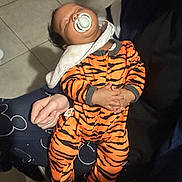 Scott a rejoint le concours — aidez-le/la à gagner de superbes lots ! baby, sleeping, pacifier, onesie, tiger_stripes, infant, hands, person, floor, tile, blanket, clothing, comfort, resting, holding, human, cute, child, indoor, peaceful
