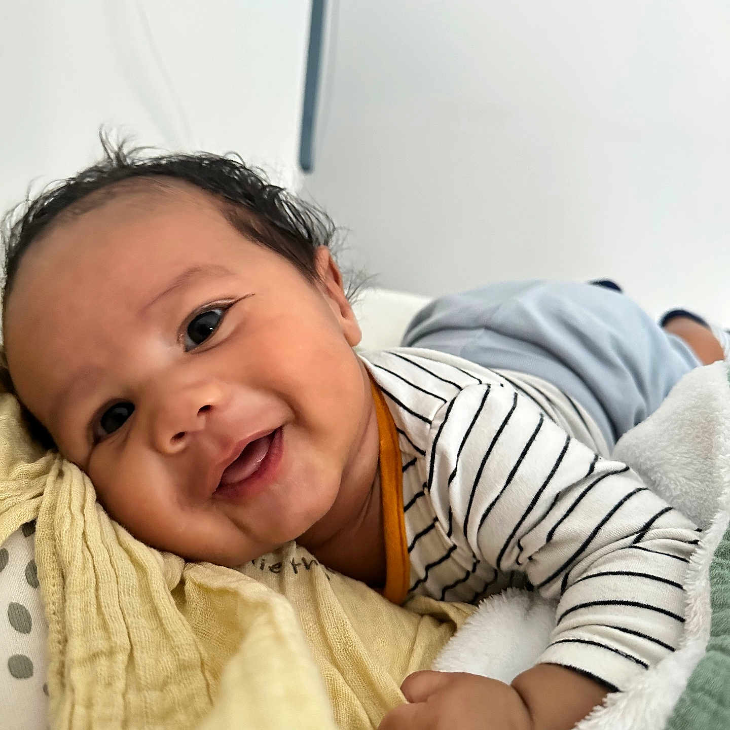 Scott participe au concours pour gagner de l'argent avec cette photo : baby, blanket, child, closeup, cozy, cute, face, hand, happy, head, indoors, infant, lying_down, portrait, skin, small_fingers, smiling, soft_texture, striped_clothing, young