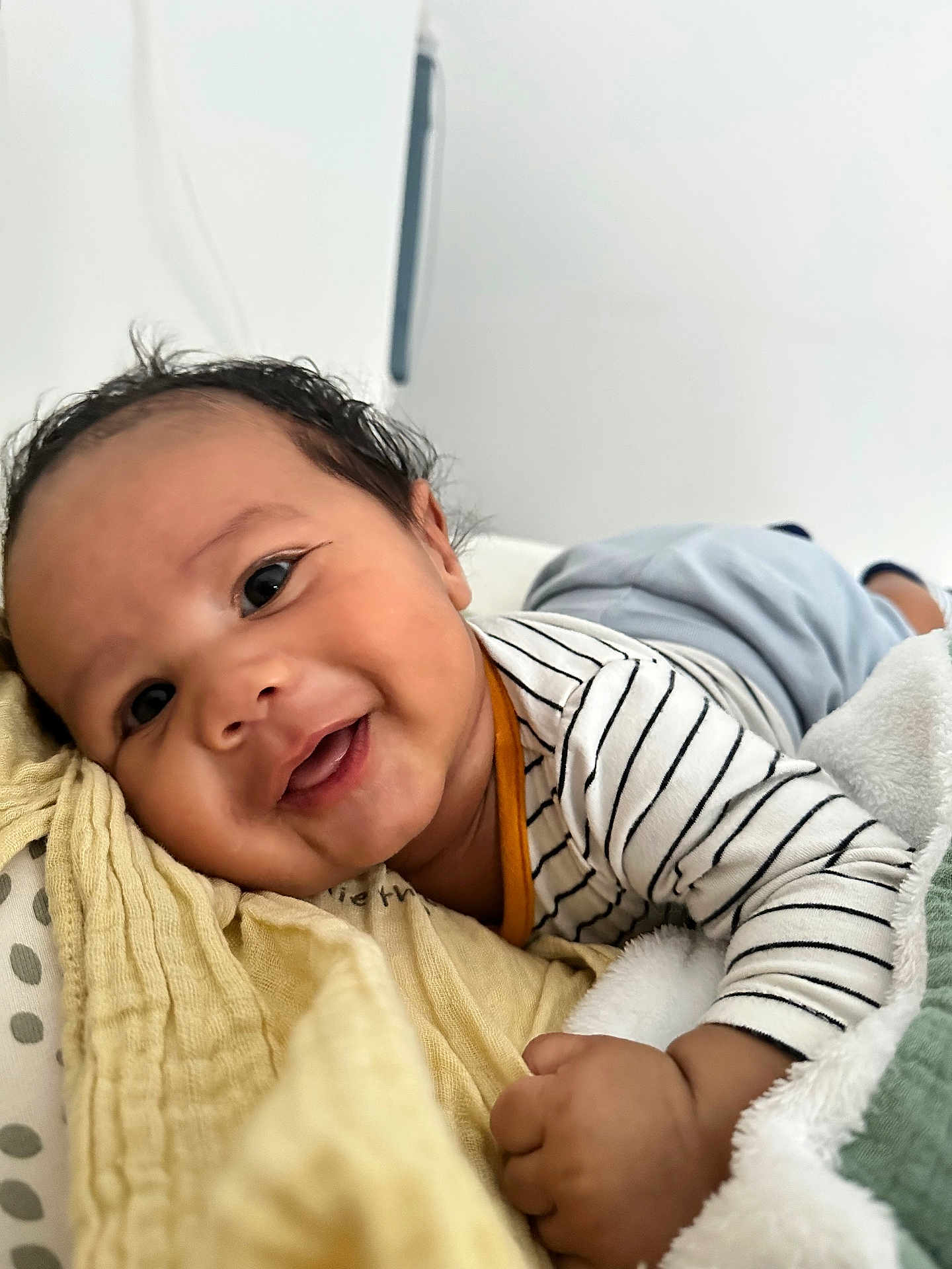 Scott participe au concours pour gagner de l'argent avec cette photo : baby, infant, smiling, face, closeup, striped_clothing, blanket, soft_texture, hand, cute, lying_down, portrait, child, happy, indoors, skin, small_fingers, head, cozy, young