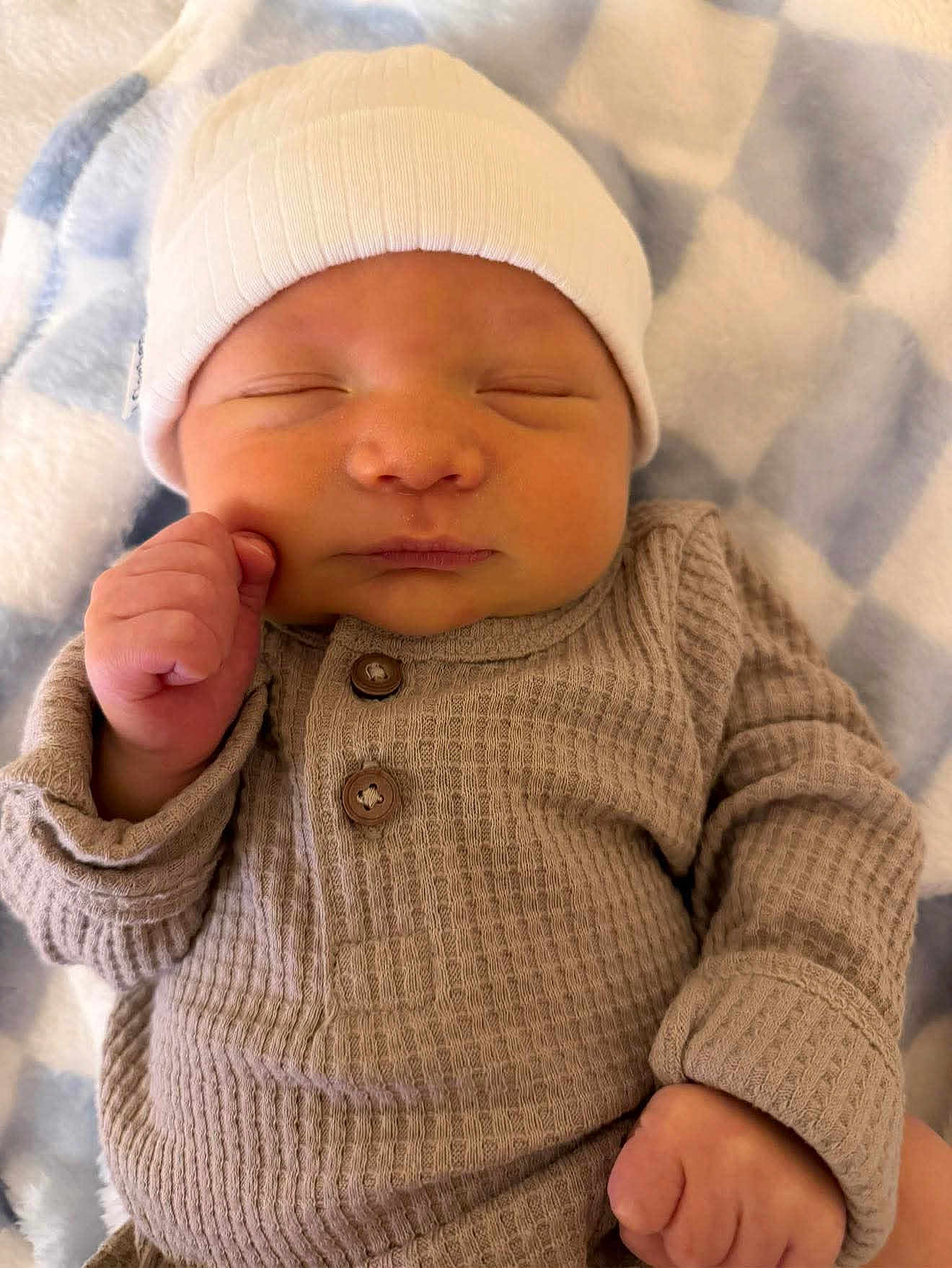 Camden is registered to the contest to win money with this photo: newborn, baby, sleeping, hat, beige_clothing, blanket, cozy, infant, soft_texture, cute, peaceful, portrait, resting, child, fist, warm, indoors, closeup, headwear, sleep