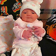 Emma joined the competition — help win amazing prizes! baby, infant, pajamas, hat, blanket, cartoon_characters, pink_clothing, white_clothing, cute, indoors, soft_toys, sleepwear, newborn, person, child, portrait, lying_down, hands, face, cozy