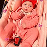 baby, car_seat, child, clothing, cozy, cute, indoor, infant, person, pink_clothing, portrait, purple_bows, red_headband, safety, seat, seatbelt, sitting, small, smiling, young_child