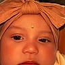 Kylie is registered to the contest to win money with this photo: adorable, baby, child, close_up, cute, emoji, expression, eyes, face, fashion_accessory, headband, headwear, human, indoors, infant, lips, portrait, skin, soft_lighting, young