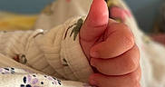 Kylie is registered to the contest to win money with this photo: baby_clothing, baby_hand, blanket, child, close_up, comfort, cozy, cute, fingers, floral_pattern, hand_gesture, infancy, infant, newborn, skin, sleeve, soft_texture, thumbs_up, tiny_fingers, warm