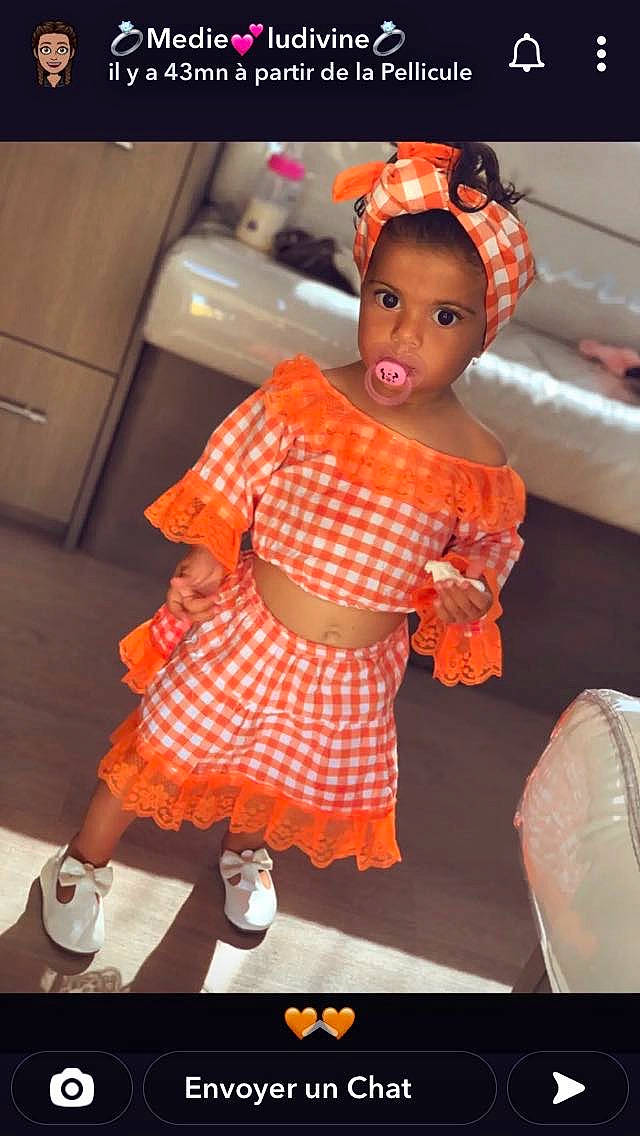Keila a rejoint le concours — aidez-le/la à gagner de superbes lots ! baby_toddler_clothing, child, day_dress, entertainment, event, fashion_design, flooring, fun, happy, human_leg, orange, pattern, peach, person, plaid, room, sock, tartan, toddler, toy