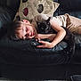 black_cat, boy, carpet, cat, child, couch, cozy, cute, hand, indoor, leather_couch, leaves_pattern, living_room, nap, pet, pillow, relaxing, remote_control, resting, sleeping